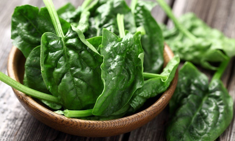 Raw spinach in brown bowl