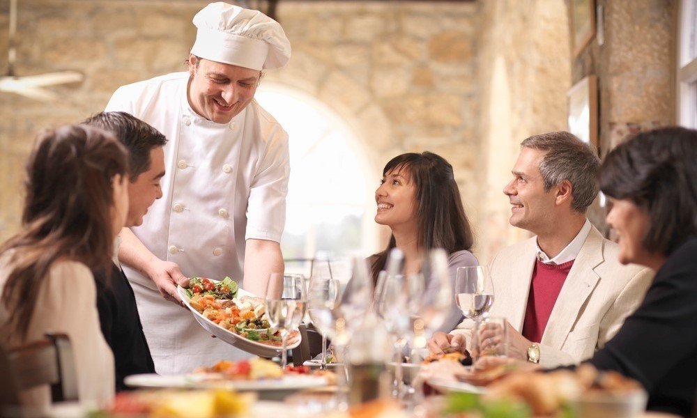 Chef serving people in restaurant